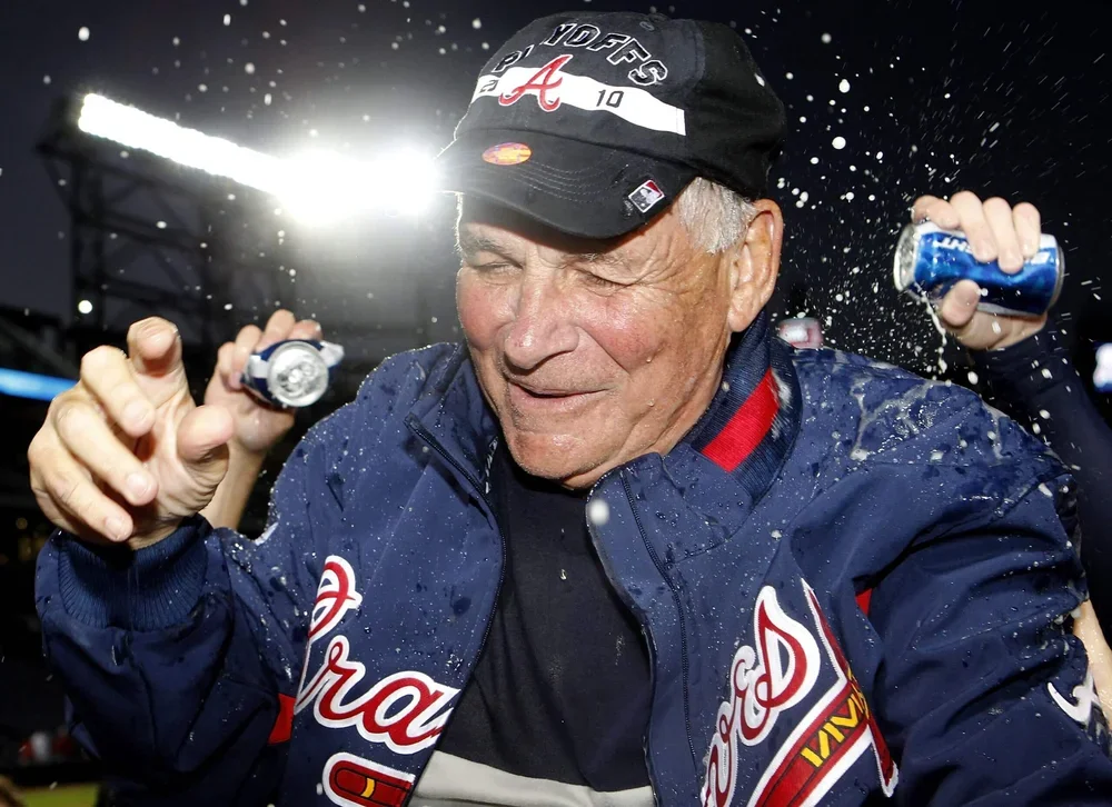 Manager Bobby Cox of the Atlanta Braves is doused by beer during an on-field playoff celebration.