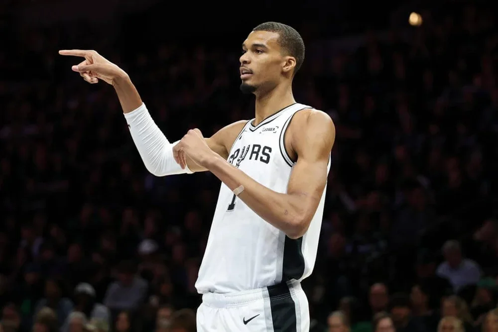 San Antonio Spurs center Victor Wembanyama points with his right hand during an NBA game.